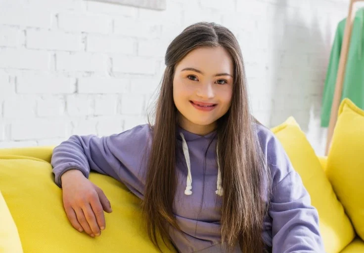 Disabled woman with down syndrome smiling happily at the camera